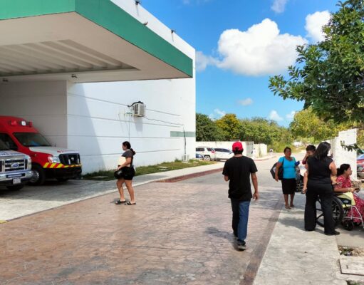 Familiares de pacientes aguardan bajo en sol en el Hospital General de Cancún